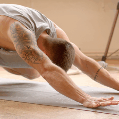 Yngre man stretchar på yogamatta